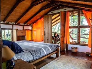 une femme assise dans une pièce avec un grand lit dans l'établissement Hotel La Casa de Francois, à San Agustín