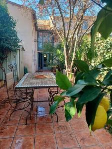 a patio with a table and chairs and a tree at Un petit oasis en plein centre de Céret. in Céret