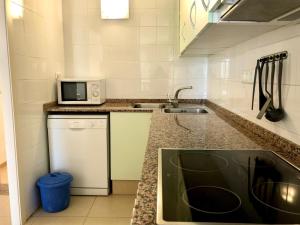a kitchen with a sink and a microwave at Duplex Ancla in L'Ametlla de Mar