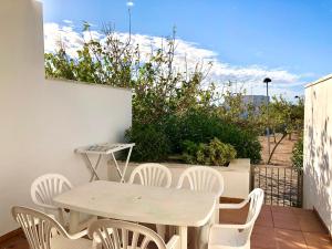 a white table and chairs on a patio with a table and chairsktop at Duplex Ancla in L'Ametlla de Mar