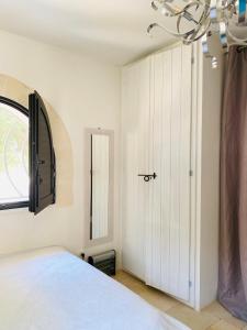 Schlafzimmer mit einem Bett, einem Fenster und einer Tür in der Unterkunft NEW SHEPHERD HOUSE, CAROVIGNO, 2 Adults + 1 child in Carovigno