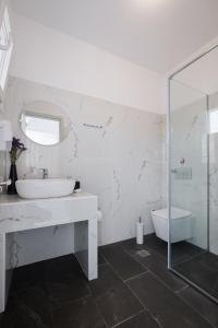 阿里拉斯的住宿－Diamond Arillas Luxury Apartments，白色的浴室设有水槽和淋浴。