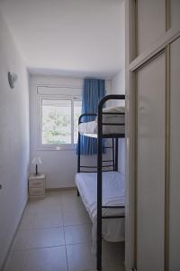 a small room with two bunk beds and a window at Duplex Ancla in L'Ametlla de Mar
