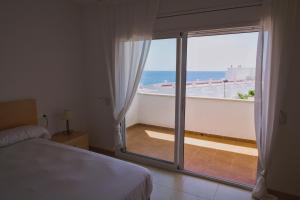 a bedroom with a bed and a view of the ocean at Duplex Ancla in L'Ametlla de Mar