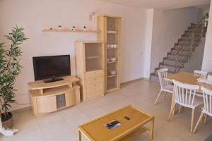 a living room with a television and a table at Duplex Ancla in L'Ametlla de Mar