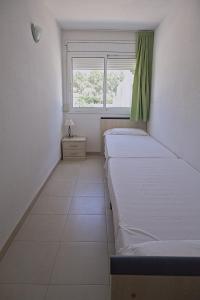 two beds in a room with a window at Duplex Ancla in L'Ametlla de Mar