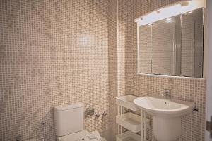 a bathroom with a white toilet and a sink at Duplex Ancla in L'Ametlla de Mar +28 photos