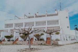a white building with two trees in front of it at Duplex Ancla in L'Ametlla de Mar