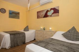 2 Einzelbetten in einem Zimmer mit gelben Wänden in der Unterkunft Casa Juleta barrierefrei in Playa Blanca