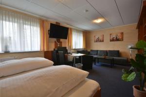 ラインバッハにあるHotel Nordのベッドとリビングルームが備わるホテルルームです。