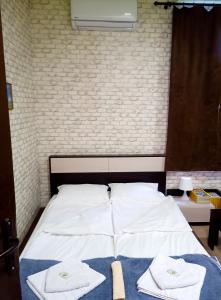 a bedroom with a bed with towels on it at Апартамент в центъра на София in Sofia