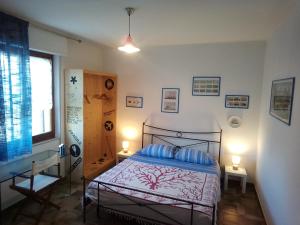 Un dormitorio con una cama con almohadas azules y una ventana en Giramondo Sardegna Affittacamere, en Alghero