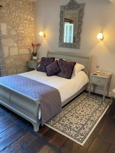 a bedroom with a bed and a mirror on the wall at Le Patio Chambres et Tables d'Hôtes in La Tour-Blanche
