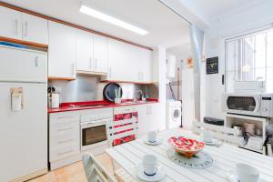 uma cozinha com armários brancos e uma mesa com uma tigela em Bliss Moments by Fidalsa em Torre de la Horadada