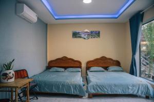 two beds in a bedroom with a blue ceiling at Homestay Bảo Bình in Ben Tre