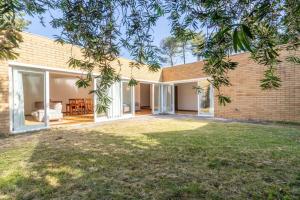 エシュポゼンデにあるQuinta da Barca Guest Houseのレンガ造りの家(大きな窓、庭付)