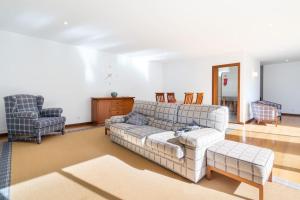 uma sala de estar com um sofá e duas cadeiras em Quinta da Barca Guest House em Esposende