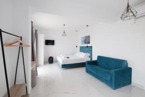 a living room with a blue chair and a bed at Diamond Arillas Luxury Apartments in Arillas