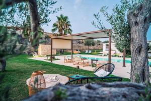 a pavilion with a table and chairs next to a pool at Le Valli di Vendicari in Noto Marina