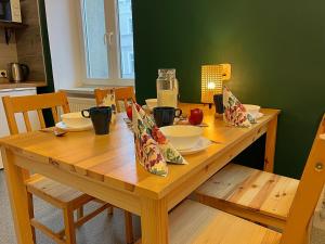 een houten tafel met borden en kommen erop bij Noclegi Pan Tadeusz in Wałbrzych