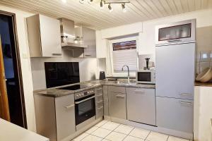 a kitchen with stainless steel appliances and a sink at Work & Stay in Kranenburg near Kleve in Kranenburg