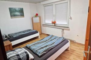 two beds in a room with a window at Work & Stay in Kranenburg near Kleve in Kranenburg