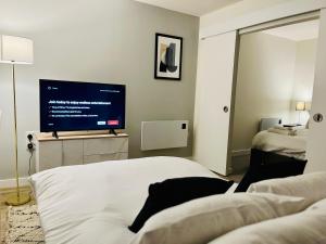 uma sala de estar com uma televisão e uma cama em Fantastic one bedroom apartment near Old Trafford Stadium em Manchester