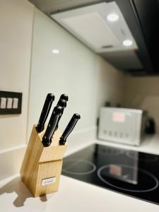 a knife block filled with knives on a kitchen counter at Fantastic one bedroom apartment near Old Trafford Stadium in Manchester