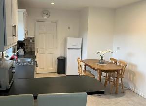 a kitchen with a table and a white refrigerator at Burren Seaside Lodge in Ballyvaughan