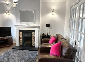 a living room with a couch and a fireplace at Burren Seaside Lodge by Trident Holiday Homes in Ballyvaughan