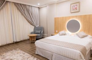 een hotelkamer met een bed en een stoel bij بيوتات الحور in Taif