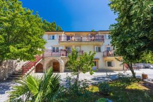 a large building with a balcony on top of it at Apartments NEVEN in Grižane