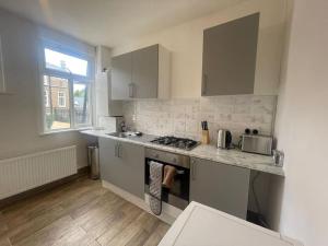 a kitchen with a stove and a counter top at Bright 2 Bedroom Flat On Tower Bridge in London