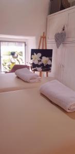 2 camas con sábanas blancas y una foto en la pared en Ca' di Rae Bed&Breakfast olistico, en Almenno San Bartolomeo