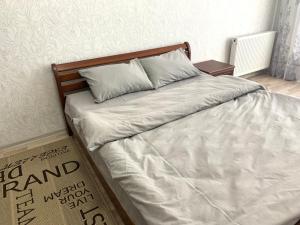 Комфортна квартира, поруч з парком في ترنوبل: سرير بشرشف ووسائد بيضاء في غرفة النوم