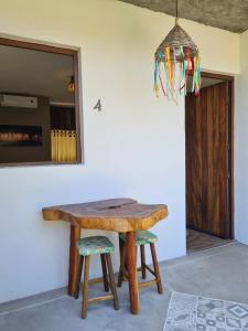 a wooden table and two stools in a room at Pousada Trilha do Mar in Praia do Frances