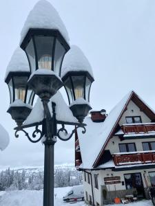 a street light covered in snow in front of a building at Harmatówka Concept Mountain in Bukowina Tatrzańska