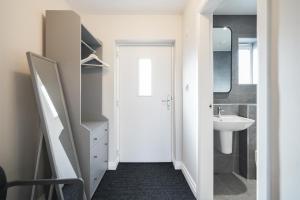 a white bathroom with a sink and a mirror at Cheshire Mews in Castleton