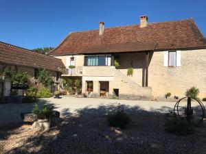 un grand bâtiment en pierre avec un toit brun dans l'établissement Maison de campagne chez Mamie 4 étoiles, à Sainte-Eulalie-dʼAns