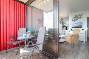 comedor con cortinas rojas, mesa y sillas en Berolina Wohnung 707 Kleiner Ankerplatz, en Dahme