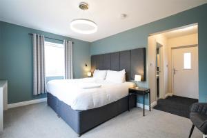 a bedroom with a large bed and a window at Cheshire Mews in Castleton