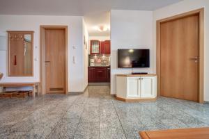 ein Wohnzimmer mit einem TV und einer Tür in der Unterkunft Ostseeresidenz Gorki- Park - 03 mit Wellness und Schwimmbad in Bansin