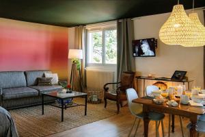 ein Wohnzimmer mit einem Sofa und einem Tisch in der Unterkunft Gîte des Puys - Pinatelle - Durtol in Durtol