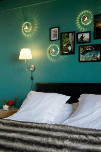 a bedroom with a bed and a green wall with mirrors at Gîte des Puys - Pinatelle - Durtol in Durtol