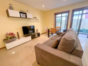 ein Wohnzimmer mit einem großen Sofa und einem TV in der Unterkunft Appartement - Plage de Furadouro - Rico's Homes in Ovar