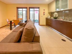 ein Wohnzimmer mit einer großen braunen Couch in einer Küche in der Unterkunft Appartement - Plage de Furadouro - Rico's Homes in Ovar