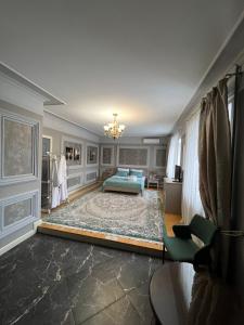 sala de estar con cama y alfombra en TURAN SEMEY GRAND HOTEL, en Semey