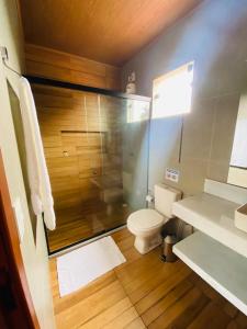 een badkamer met een toilet en een glazen douche bij Casa Passarinho in Vale do Capao