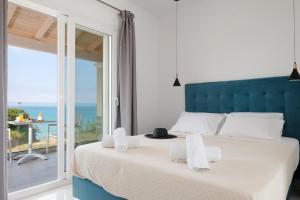 a bedroom with a large bed with a view of the ocean at Diamond Arillas Luxury Apartments in Arillas