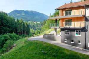 a house on the side of a road next to a mountain at Oberstdorf Hostel in Oberstdorf